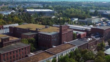 Hava perspektifi Leipzig pamuk fırıldak fabrikası endüstriyel mimarisi sergiliyor, tuğla binalar ve belirgin bir bacayla karakterize ediliyor. panorama genel görünüm dronu 