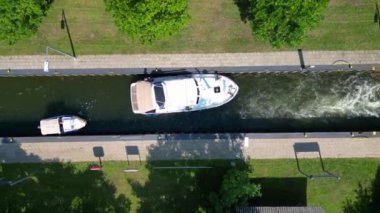 Almanya 'nın Himmelpfort kırsalında güneşli bir yaz gününde botlar tarafından kullanılan kanal kanalı manzarası. İHA kamerası aşağıya bakıyor 