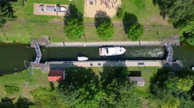 Almanya 'nın Himmelpfort kırsalında güneşli bir yaz gününde botlar tarafından kullanılan kanal kanalı manzarası. Yukarıdan insansız hava aracı görüntüleri 