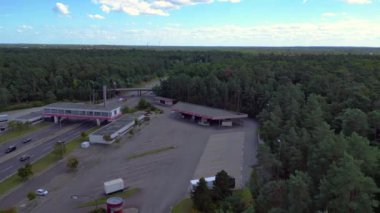 Otoyol manzaralı bir dinlenme tesisi ve çok şeritli bir otoyolda giden arabalar. uçuş üstü insansız hava aracı 