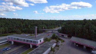 Otoyol manzaralı bir dinlenme tesisi ve çok şeritli bir otoyolda giden arabalar. Ters İHA uçuşu 