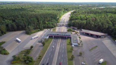 Otoyol manzaralı bir dinlenme tesisi ve çok şeritli bir otoyolda giden arabalar. geniş yörünge görünümü dronu 