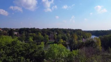 Halle Saale Kroellwitz 'in Almanya' daki hava manzarası ormanı, nehri, köprüyü ve şehrin kırmızı tuğlalı çatılarını gösteriyor. İHA yükseliyor 