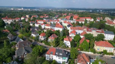 Halle Saale Kroellwitz 'in Almanya' daki hava manzarası ormanı, nehri, köprüyü ve şehrin kırmızı tuğlalı çatılarını gösteriyor. Yukarıdan insansız hava aracı görüntüleri 