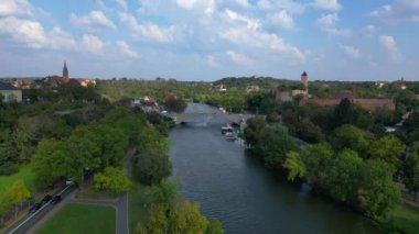 Halle Saale Kroellwitz 'in Almanya' daki hava manzarası ormanı, nehri, köprüyü ve şehrin kırmızı tuğlalı çatılarını gösteriyor. uçuş üstü insansız hava aracı 