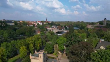 Halle Saale Kroellwitz 'in Almanya' daki hava manzarası ormanı, nehri, köprüyü ve şehrin kırmızı tuğlalı çatılarını gösteriyor. Yukarıdan insansız hava aracı görüntüleri 
