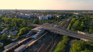 Berlin 'deki Bornholmer Sokağı Ajan Bridge, Almanya' da güneşli bir yaz gününde hava perspektifinden tren rayları görünüyor. panorama yörünge dronu 