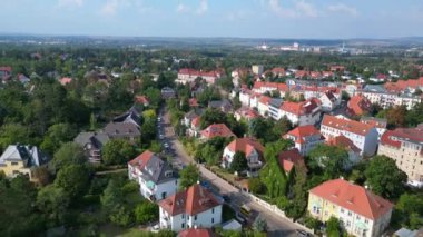 Halle Saale Kroellwitz 'in Almanya' daki hava manzarası ormanı, nehri, köprüyü ve şehrin kırmızı tuğlalı çatılarını gösteriyor. Ters İHA uçuşu 
