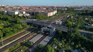 Berlin 'deki Bornholmer Sokağı Ajan Bridge, Almanya' da güneşli bir yaz gününde hava perspektifinden tren rayları görünüyor. panorama yörünge dronu 