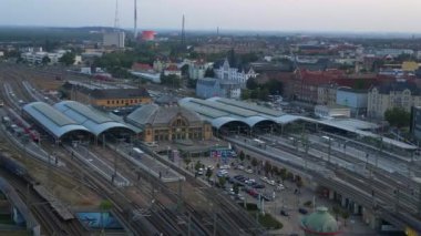 Şehir merkezine ve banliyöye giden rayları birleştiren modern bir tren istasyonunun havadan görüntüsü. geniş yörünge görünümü dronu 