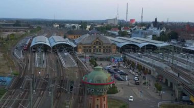 Şehir merkezine ve banliyöye giden rayları birleştiren modern bir tren istasyonunun havadan görüntüsü. İHA alçalıyor 