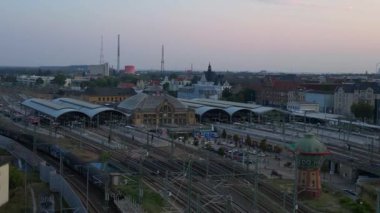 Şehir merkezine ve banliyöye giden rayları birleştiren modern bir tren istasyonunun havadan görüntüsü. İHA yükseliyor 