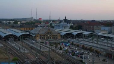 Şehir merkezine ve banliyöye giden rayları birleştiren modern bir tren istasyonunun havadan görüntüsü. Ters İHA uçuşu 