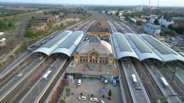 Şehir merkezine ve banliyöye giden rayları birleştiren modern bir tren istasyonunun havadan görüntüsü. panorama yörünge dronu 