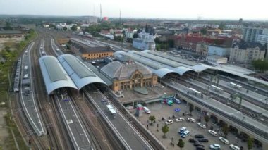 Şehir merkezine ve banliyöye giden rayları birleştiren modern bir tren istasyonunun havadan görüntüsü. Ters İHA uçuşu 