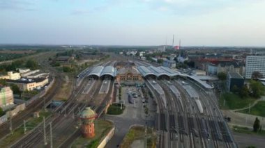 Şehir merkezine ve banliyöye giden rayları birleştiren modern bir tren istasyonunun havadan görüntüsü. geniş yörünge görünümü dronu 