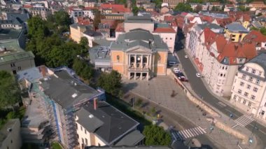 Halle saale, Almanya 'da güneşli bir günde opera binasının önünde fıskiyeler çağlıyor. panorama yörünge dronu 