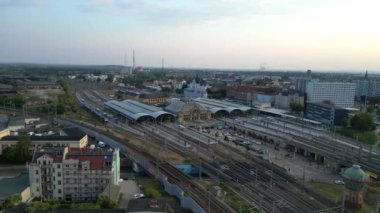 Şehir merkezine ve banliyöye giden rayları birleştiren modern bir tren istasyonunun havadan görüntüsü. geniş yörünge görünümü dronu 