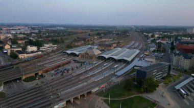 Şehir merkezine ve banliyöye giden rayları birleştiren modern bir tren istasyonunun havadan görüntüsü. panorama yörünge dronu 