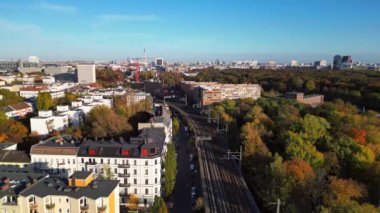 Berlin 'de bir köprüyü geçen trenin manzarası. Etrafı canlı sonbahar yapraklarıyla çevrili. Yukarıdan insansız hava aracı görüntüleri 