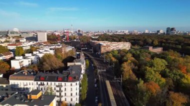 Berlin 'de bir köprüyü geçen trenin manzarası. Etrafı canlı sonbahar yapraklarıyla çevrili. Yukarıdaki İHA 'dan izlenen çekim 
