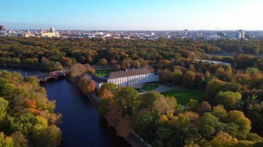 Tiergarten Park, Berlin, Almanya 'da canlı sonbahar yeşillikleri arasında yer alan Schloss Bellevue Sarayı' nın havadan görünüşü. geniş yörünge görünümü dronu 