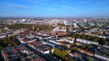 Berlin, Almanya 'da güneşli bir günde binalar ve sonbahar ağaçlarıyla çevrili bir arazinin havadan görünüşü. Sağ drona döndür 