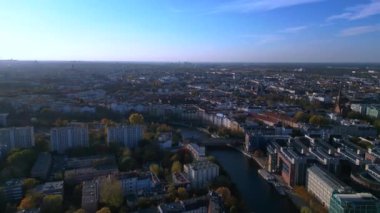 Berlin, Almanya 'da güneşli bir günde binalar ve sonbahar ağaçlarıyla çevrili bir arazinin havadan görünüşü. panorama genel görünüm dronu 
