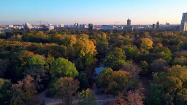 Berlins Tiergarten Parkı 'ndaki renkli sonbahar yeşilliklerinin havadan görünüşü. Şehir silueti uzakta. hız rampası hiper hareket zaman aşımı 