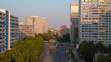 Berlin şehir manzarası, konut binaları, Coca Cola reklam panosu ve caddelerde hareket eden arabalar. İHA alçalıyor 