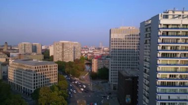 Berlin şehir manzarası, konut binaları, Coca Cola reklam panosu ve caddelerde hareket eden arabalar. Ters İHA uçuşu 