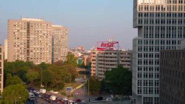 Berlin şehir manzarası, konut binaları, Coca Cola reklam panosu ve caddelerde hareket eden arabalar. Ters İHA uçuşu 