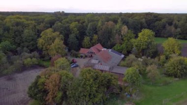 Geleneksel Kuzey Alman çiftliği ormanda yuva yapmış, yukarıdan çekilmiş. panorama yörünge dronu 