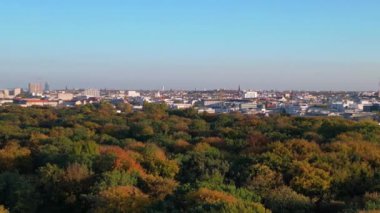 Berlins Tiergarten Parkı 'ndaki renkli sonbahar yeşilliklerinin havadan görünüşü. Şehir silueti uzakta. panorama genel görünüm dronu 