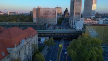 Hayvanat bahçesi tren istasyonunun ve Berlin, Almanya 'da gün batımında çevreleyen şehir manzarasının görüntüsü yükseldi. Yukarıdan insansız hava aracı görüntüleri 