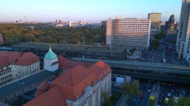 Hayvanat bahçesi tren istasyonunun ve Berlin, Almanya 'da gün batımında çevreleyen şehir manzarasının görüntüsü yükseldi. panorama genel görünüm dronu 