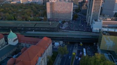 Hayvanat bahçesi tren istasyonunun ve Berlin, Almanya 'da gün batımında çevreleyen şehir manzarasının görüntüsü yükseldi. Yukarıdan aşağıya doğru uçur 