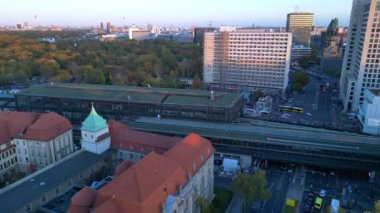 Hayvanat bahçesi tren istasyonunun ve Berlin, Almanya 'da gün batımında çevreleyen şehir manzarasının görüntüsü yükseldi. İHA yükseliyor 