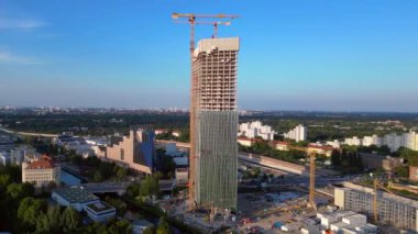 Berlin 2024 'teki Estrel Kulesi' nin inşaat alanında. Arka planda vinçler ve şehir manzarası var. panorama genel görünüm dronu 
