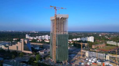 Berlin 2024 'teki Estrel Kulesi' nin inşaat alanında. Arka planda vinçler ve şehir manzarası var. geniş yörünge görünümü dronu 