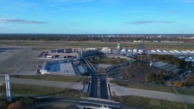Berlin Tegel Havaalanı 'nın hava görüntüsü ana terminali, kontrol kulesini, hangarları ve çevre altyapıyı gösteriyor. İHA alçalıyor 