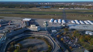 Berlin Tegel Havaalanı 'nın hava görüntüsü ana terminali, kontrol kulesini, hangarları ve çevre altyapıyı gösteriyor. geniş yörünge görünümü dronu 