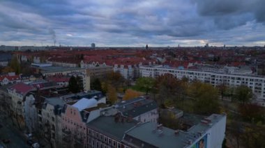 Berlin Steglitz 'in renkli binaların ve kasvetli bir sonbahar gününde bulutlu gökyüzünün bulunduğu havadan bir şehir. İHA yükseliyor 