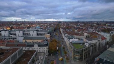Berlin 'in çatılarının ve Schlossstrasse caddesinin bulutlu bir günde renkli sonbahar ağaçlarıyla hava manzarası. uçuş üstü insansız hava aracı 