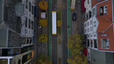 Berlin 'in çatılarının ve Schlossstrasse caddesinin bulutlu bir günde renkli sonbahar ağaçlarıyla hava manzarası. Drone 'u yukarı eğ 