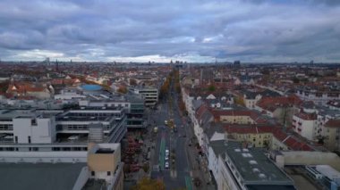 Berlin 'in çatılarının ve Schlossstrasse caddesinin bulutlu bir günde renkli sonbahar ağaçlarıyla hava manzarası. Ters İHA uçuşu 