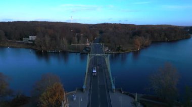 Glienicke Köprüsü 'nün Potsdam ve Berlin arasında uzanan havadan görünüşü, sonbahar yaprakları ve mavi gökyüzü. Yukarıdan insansız hava aracı görüntüleri 