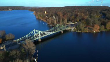 Havel nehrinin üzerindeki glienicke köprüsünün renkli bir sonbahar günbatımında üzerinde arabalar geziniyor. Yukarıdan insansız hava aracı görüntüleri 