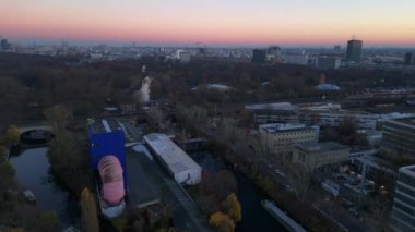 Berlin zoolojik bahçesinin, demiryollarının ve şehir manzarasının altın saat günbatımında görüntüsü. panorama genel görünüm dronu 