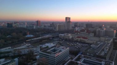 Berlin zoolojik bahçesinin, demiryollarının ve şehir manzarasının altın saat günbatımında görüntüsü. İHA yükseliyor 